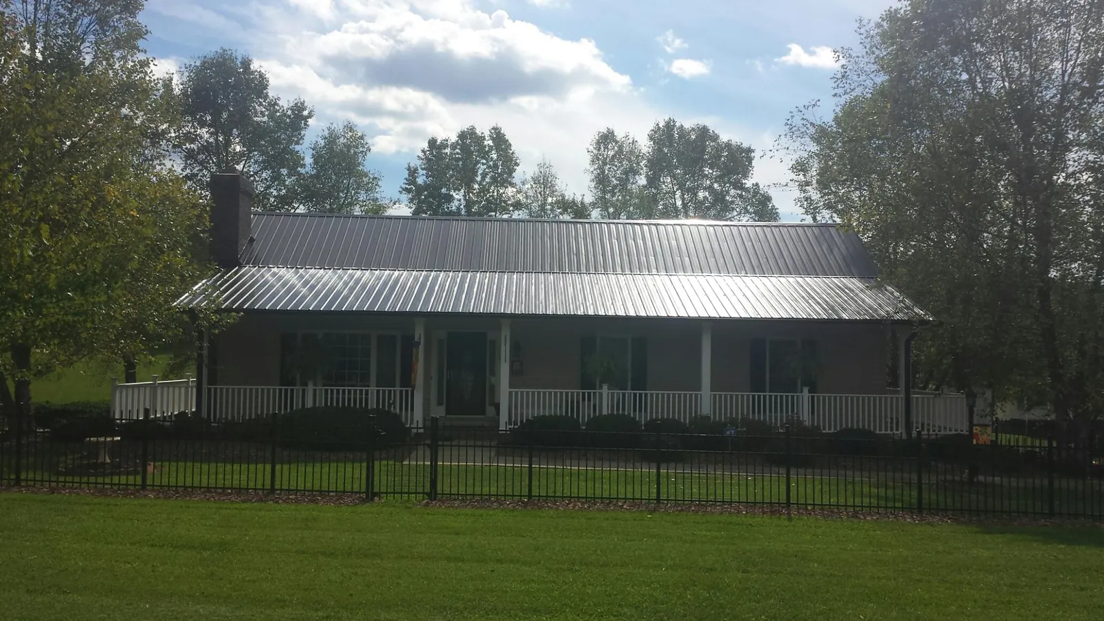 Gray metal roof on a brick ranch with a full width front porch — Gutter Guard Installation work by our crew in Santa Paula